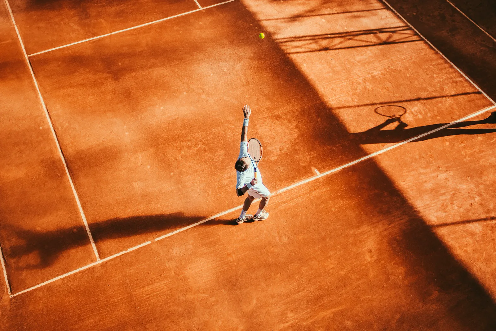 Tennis court under evening light with hard-court lines