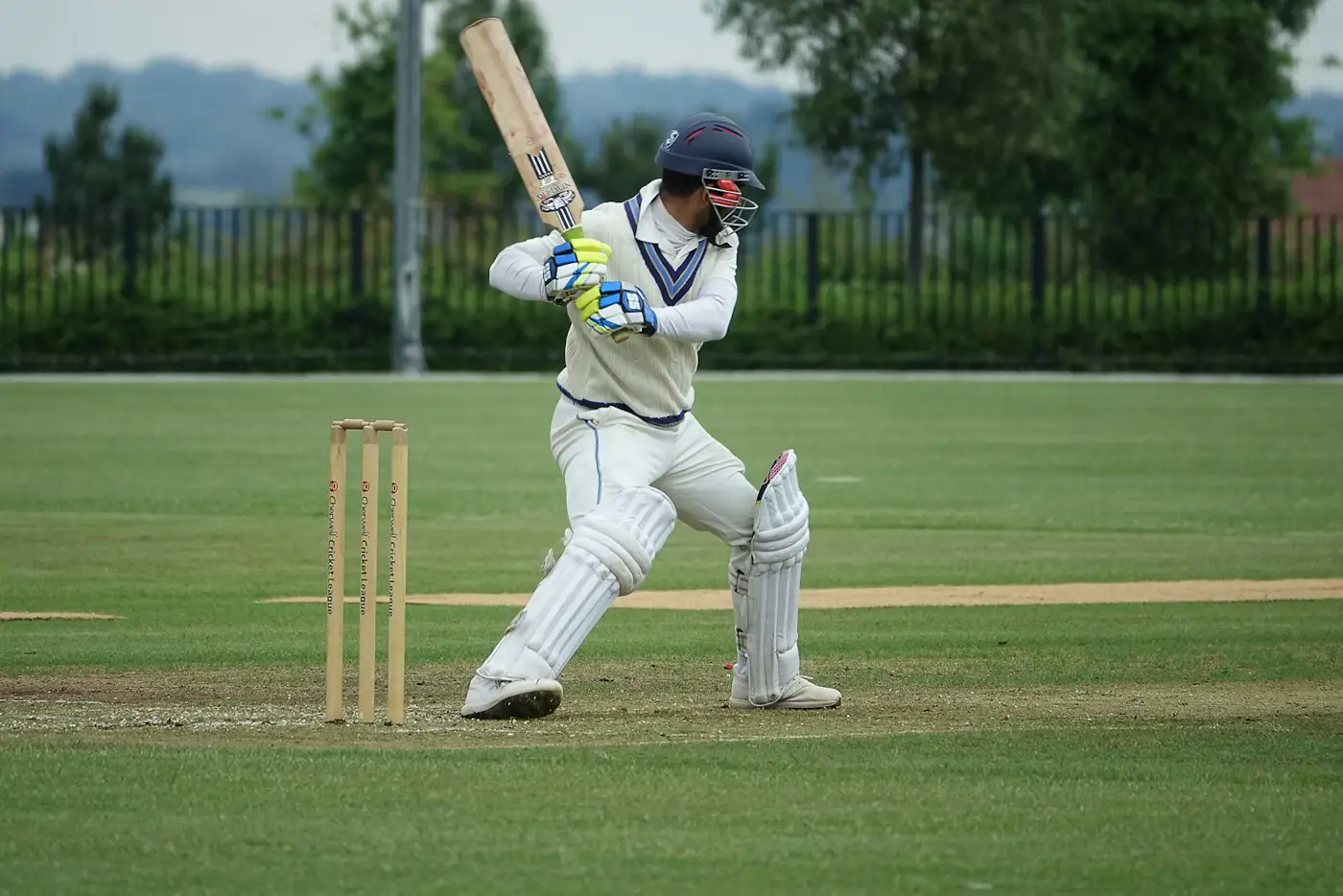 Batter in whites waiting at the crease beside the stumps